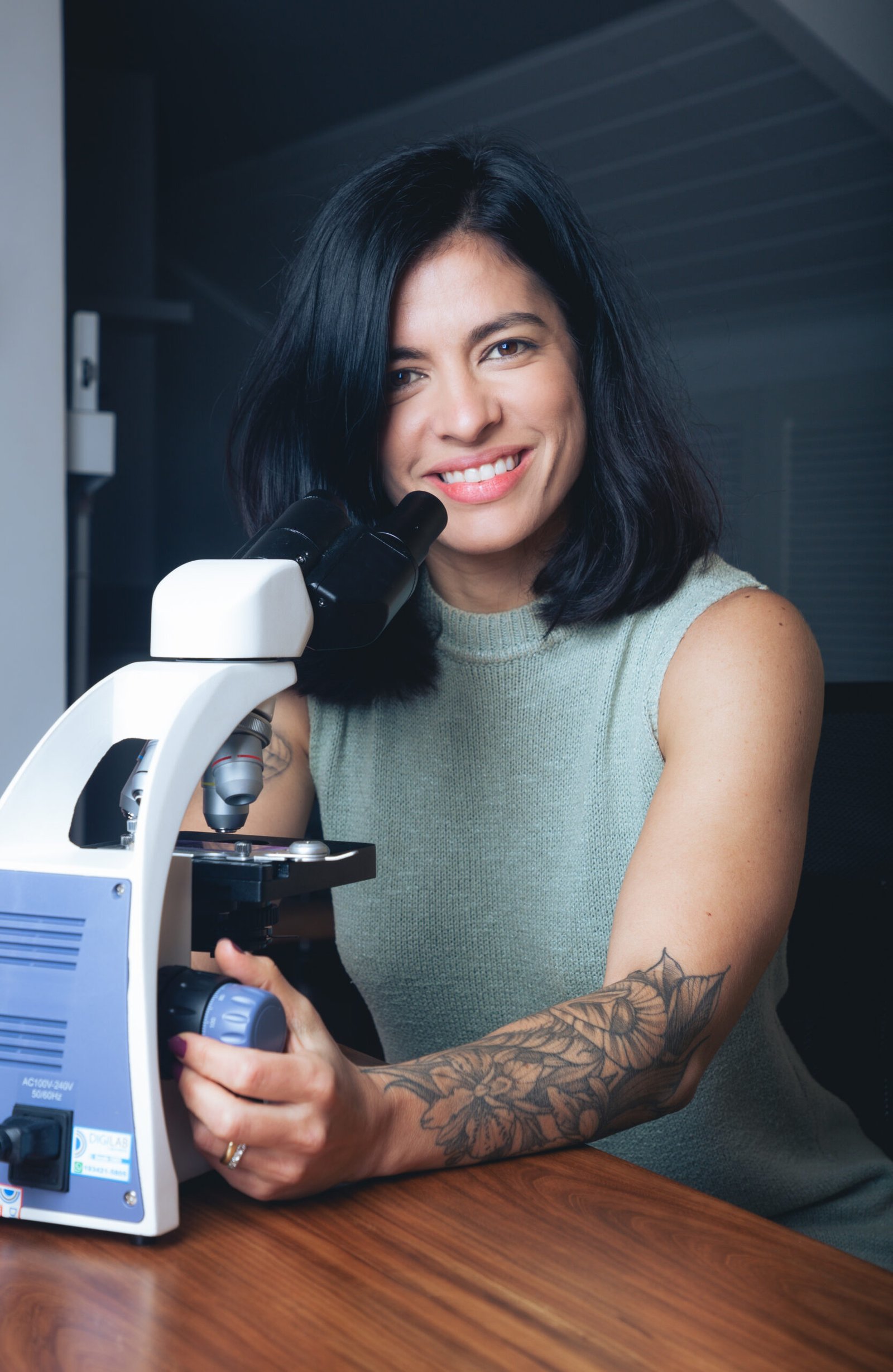 Dra. Fernanda Satty ao lado do microscópio utilizado na investigação de sintomas vulvovaginais recorrentes